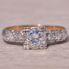 an engagement ring with three stone diamonds on the sides and two rows of side stones