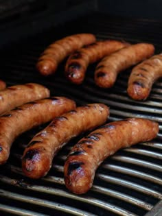 several sausages are being cooked on the grill