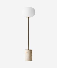 a white lamp with a gold base and a round light shade on it's end