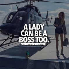 a lady is standing next to a helicopter and looking at her cell phone with the caption, a lady can be a boss too