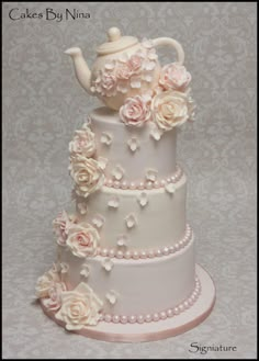 a wedding cake with flowers and a teapot on top