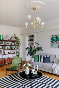 a living room filled with furniture and a large rug on top of a hard wood floor