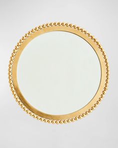 a round mirror with beading around the edges