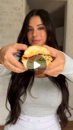 a woman holding a sandwich in her hands