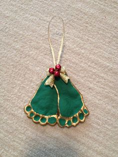 a green christmas ornament hanging from a string on top of a white table