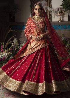 a woman in a red and gold bridal gown, with her hands on her hips