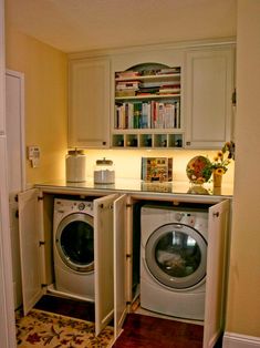 a washer and dryer in a small room next to a book shelf on the wall