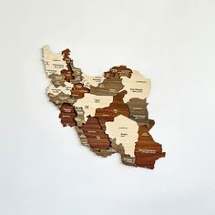 a wooden cutout map of the united states on a white wall in an art gallery