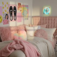 a bedroom with pink bedding, pillows and pictures on the wall