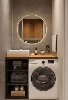 a washer and dryer in a small room with a mirror above the washer