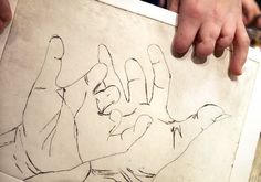 a person holding up a drawing with their hands