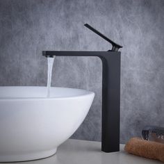 a black faucet with a white bowl underneath it