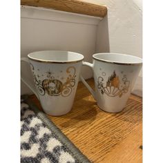 two coffee cups sitting on top of a wooden table