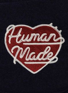 an embroidered heart with the words human made in white lettering on black fleey fabric