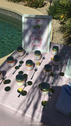 there are many spoons and bowls on the table next to the pool with a sign that says, don't let baby fool