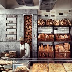 a man standing in front of a counter filled with bread