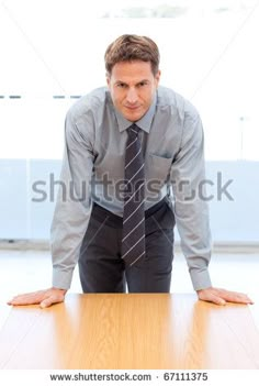 a man leaning over a wooden table in an office