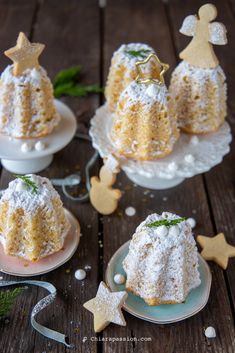 three small cakes on plates with christmas decorations around them