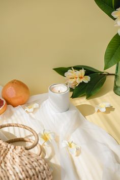 a table topped with a vase filled with flowers next to a candle and other items