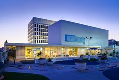 an empty building is lit up at night with colorful lights on the front and side