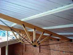 the inside of a building with exposed wood beams and metal bars hanging from it's ceiling