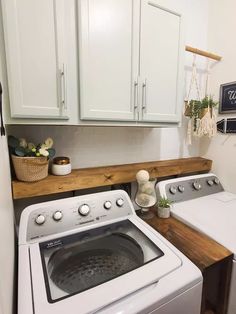 a washer and dryer in a small laundry room with white cabinetry, wood countertop, and wooden flooring