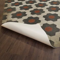 an area rug that has been laid out on the floor with some white and red tiles