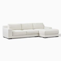 a white sectional couch sitting on top of a white floor