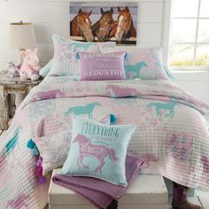 a bed with pink and blue comforters on top of it