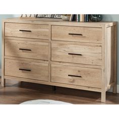 a wooden dresser sitting on top of a hard wood floor next to a white rug