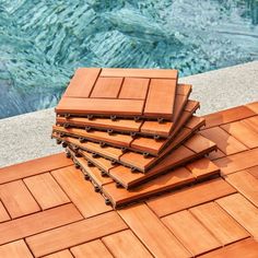 a stack of wooden boards sitting on top of a tiled floor next to a swimming pool