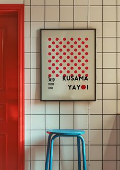 a blue stool sitting in front of a red door next to a white tiled wall