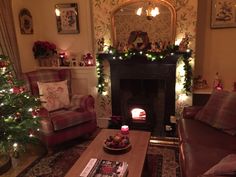 a living room filled with furniture and a fire place next to a christmas decorated tree