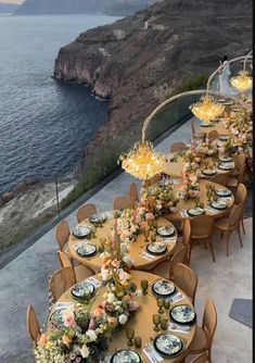 an outdoor dining area overlooking the ocean with tables and chairs set up for formal dinner