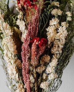 dried flowers are arranged in a vase on a table