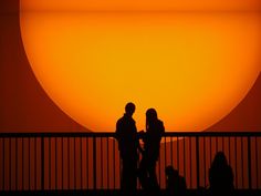 two people are standing in front of the sun