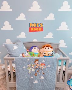 there is a baby crib in the room with toy story characters and clouds on the wall