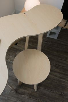 an office desk with two circular tables on one side and a lamp on the other