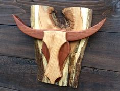 a wood carving of a bull's head on a wooden planks wall hanging