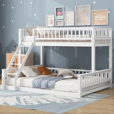 a white bunk bed sitting on top of a wooden floor next to a blue wall