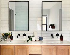 a bathroom with two sinks and mirrors on the wall