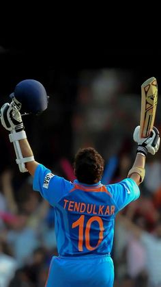 a man holding his hands up in the air while wearing a helmet and batting gloves