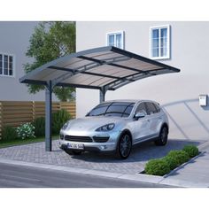 a car is parked in front of a house with a carport attached to it