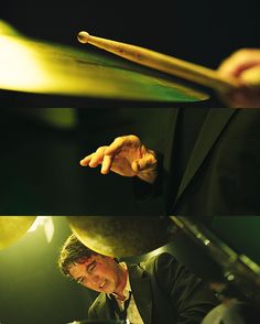 a man in a suit and tie playing the drums with his hands on the drum sticks