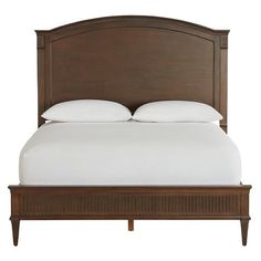 the headboard and foot board of a bed with white pillows on top of it