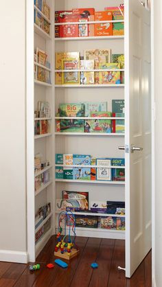 an open book shelf with toys and books on it in a room next to a door