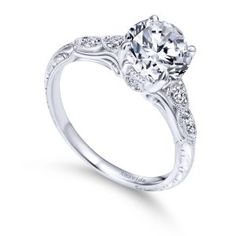 a white gold engagement ring with an oval center stone and pave set diamonds on the sides