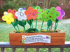 there are many flowers in the pot on the fence post, which is decorated with magnets