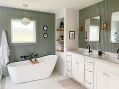 a large white bath tub sitting under two mirrors