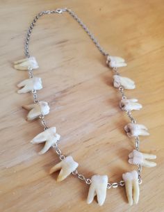 a necklace with tooth beads on a wooden table